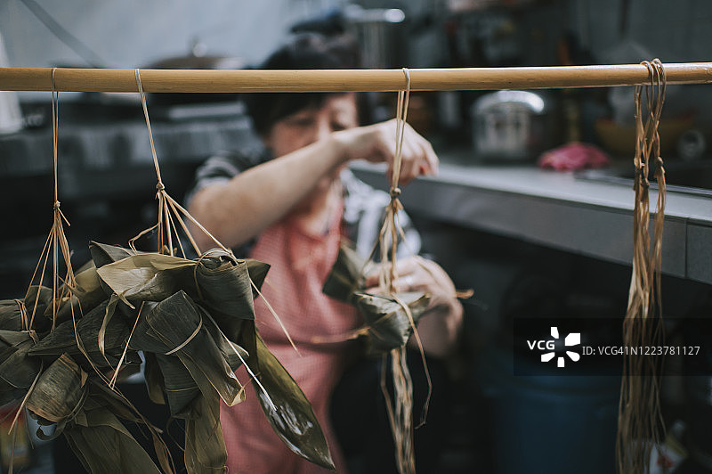 中国老年妇女在厨房准备粽子，为端午节做准备图片素材