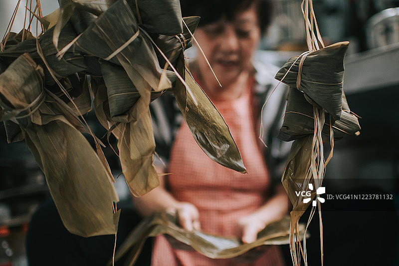 中国老年妇女在厨房准备粽子，为端午节做准备图片素材