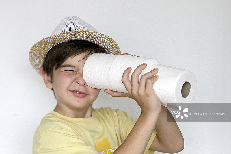 男孩透过卫生纸卷筒观察图片素材