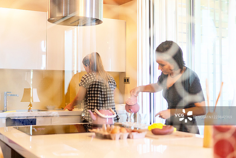 女人在厨房里倒土耳其茶图片素材