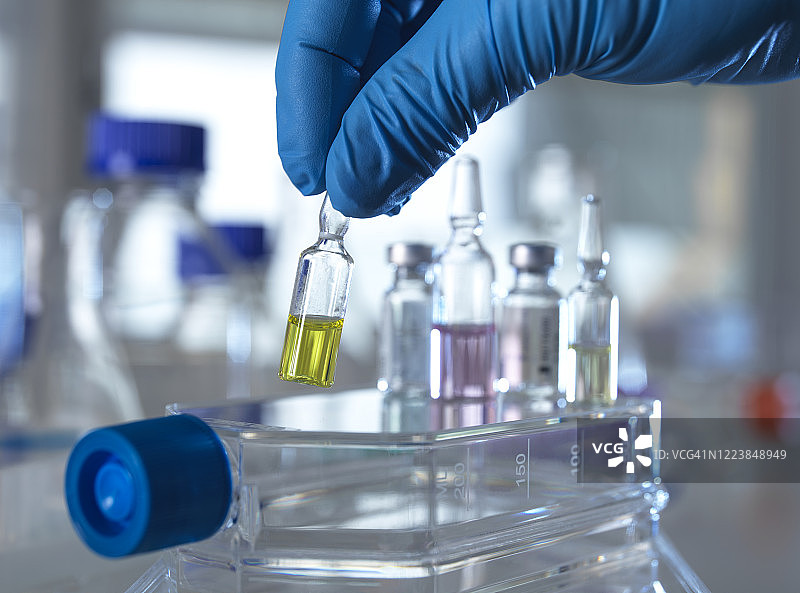 在实验室中拿起药物试剂瓶图片素材