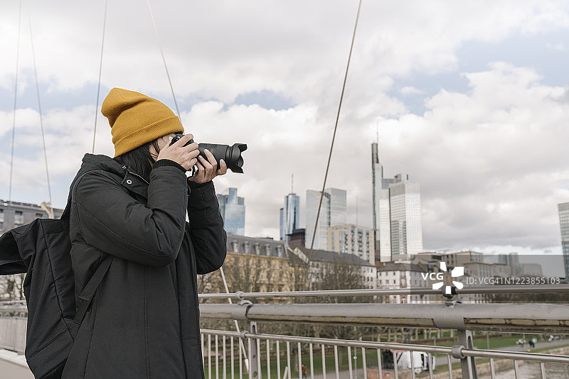 游客在德国法兰克福的桥上用相机拍照图片素材
