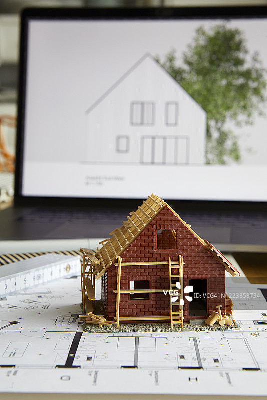 建设计划上的房屋所有权建筑模型，背景为笔记本电脑图片素材