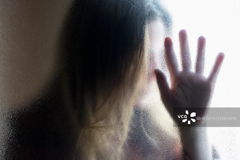 玻璃窗后的中年妇女图片素材