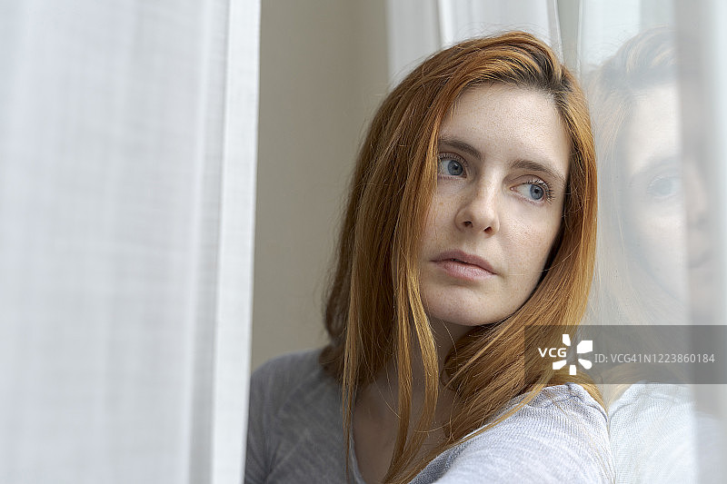 望向窗外的严肃年轻女性的肖像图片素材
