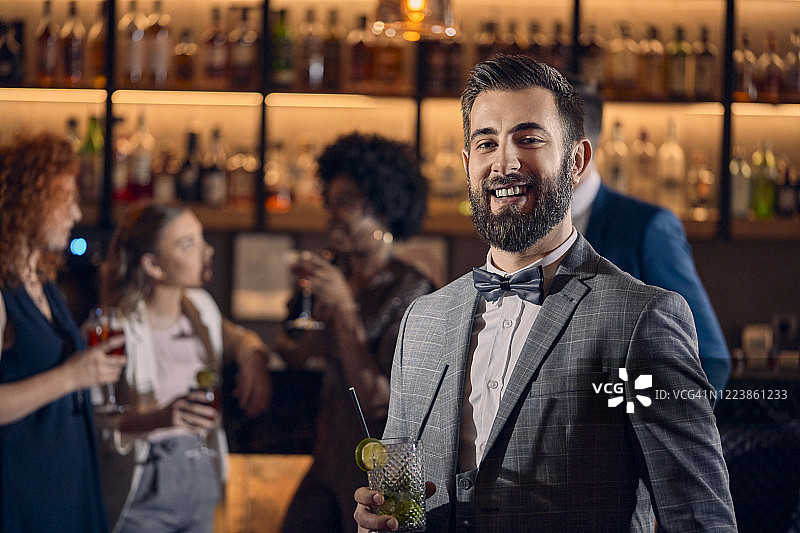快乐的年轻男人在酒吧喝鸡尾酒图片素材