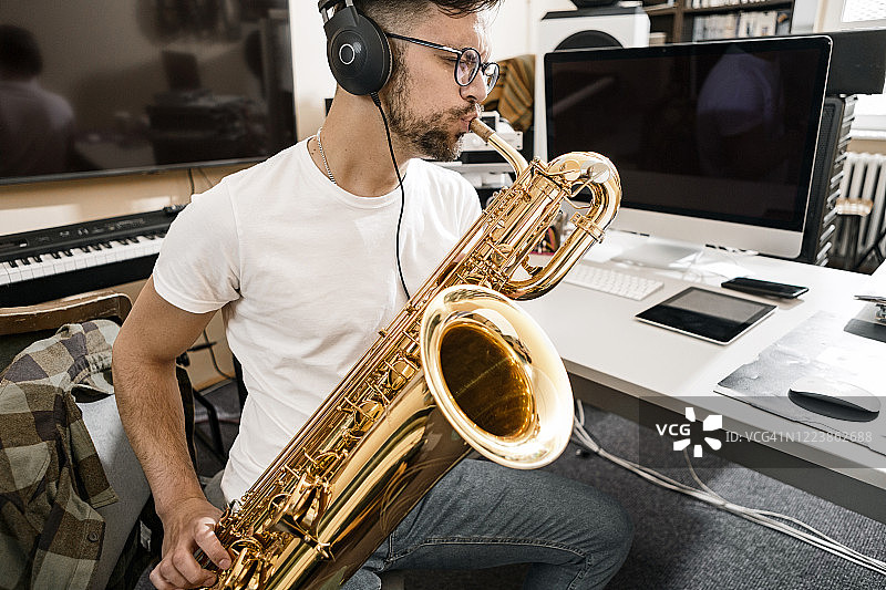 年轻男人热情演奏萨克斯图片素材