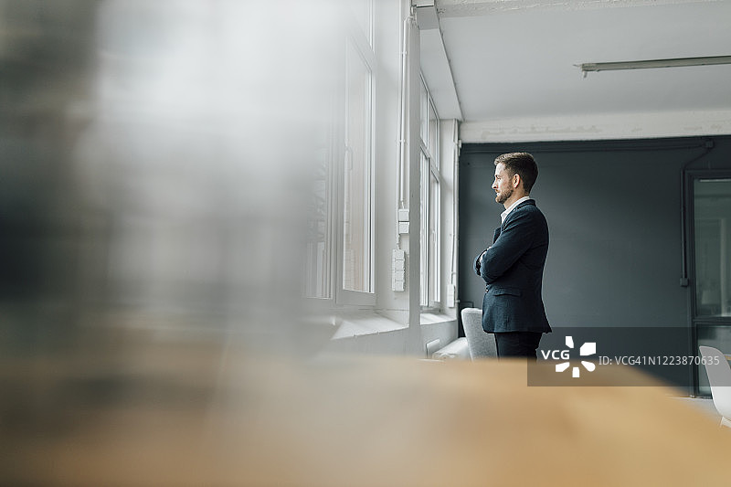 办公室里，望着窗外的黑发商人肖像图片素材