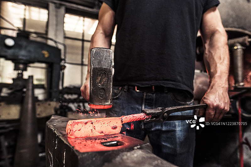 刀匠在热大马士革钢上撒硼砂图片素材