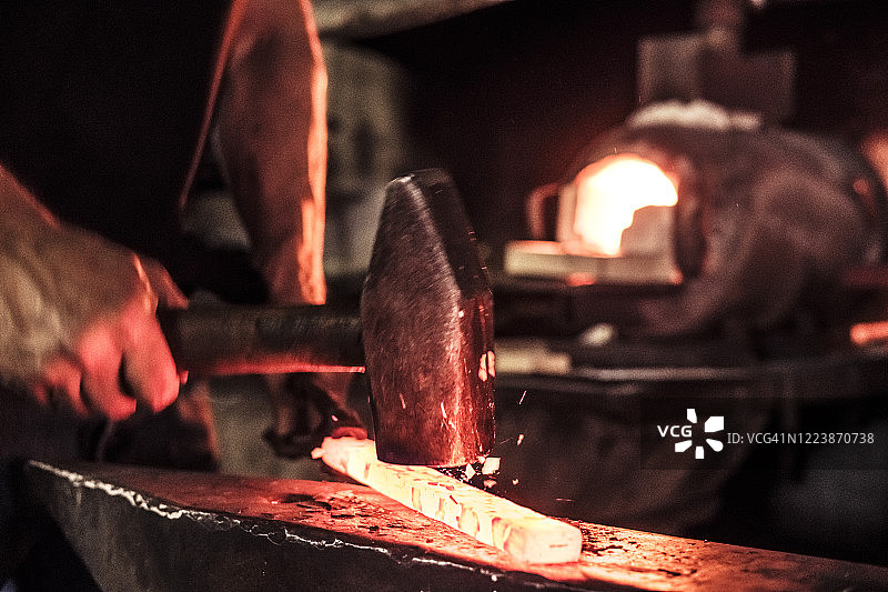 刀匠工作，锤击大马士革钢时飞溅的钢屑图片素材