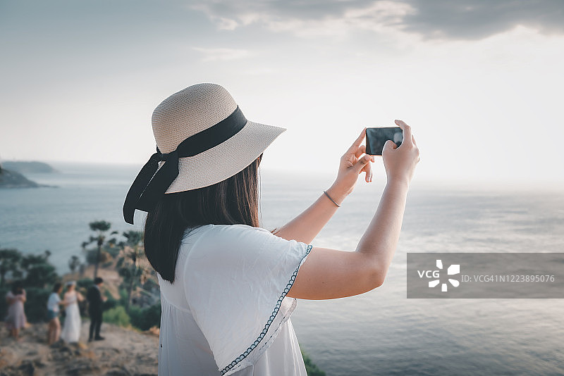 在普吉岛蓬贴海岬观光时玩乐的游客，拍摄普吉府海景的亚洲女性，享受旅行探索之旅图片素材