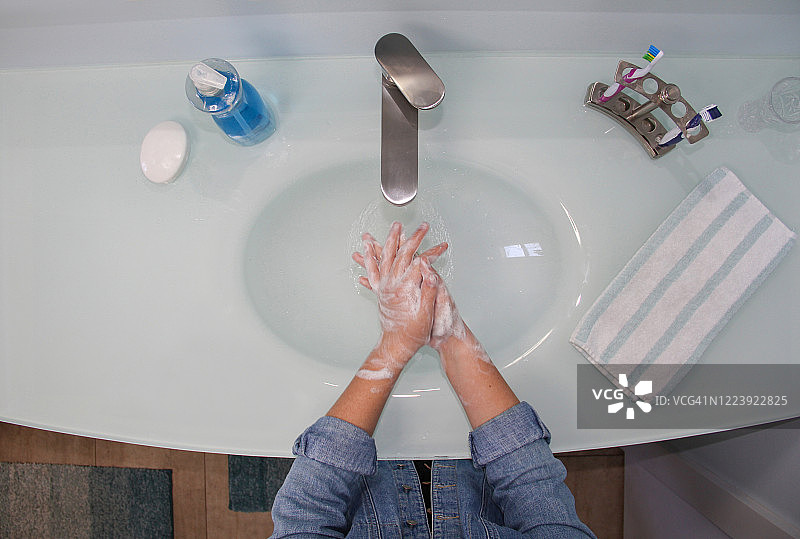 孩子在浴室里用肥皂洗手图片素材