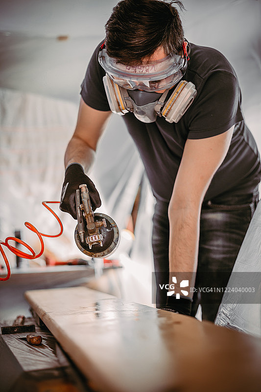 在车间喷漆木板的男人图片素材