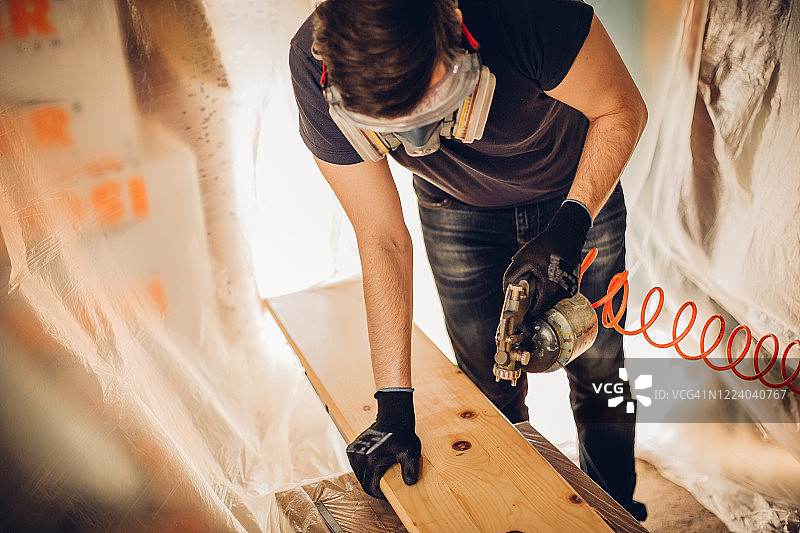 在车间喷漆木板的男人图片素材