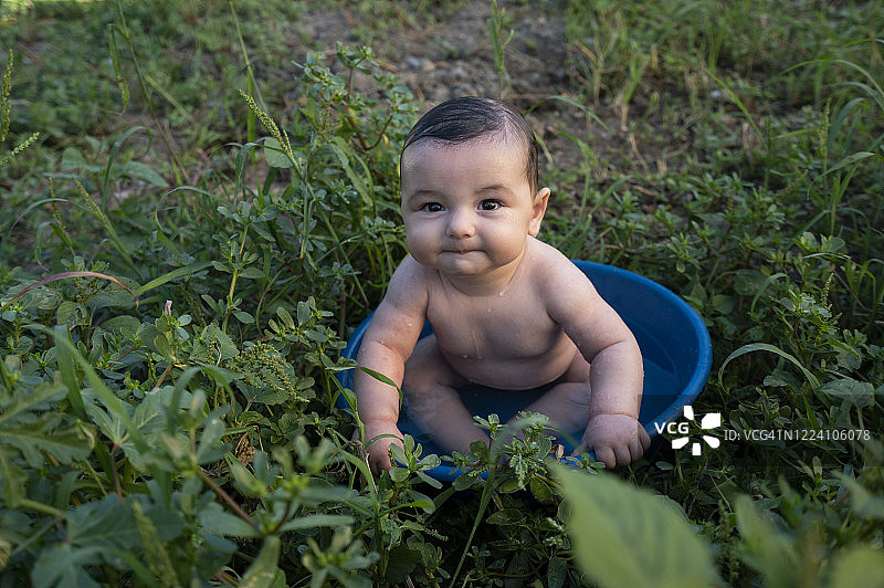 在花园里盆浴的可爱小男婴图片素材