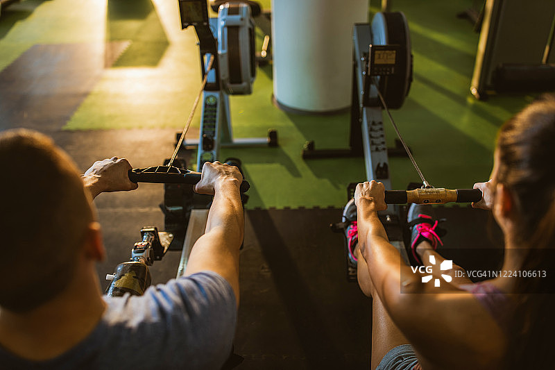 健身房内运动情侣在划船机上锻炼的背影图片素材