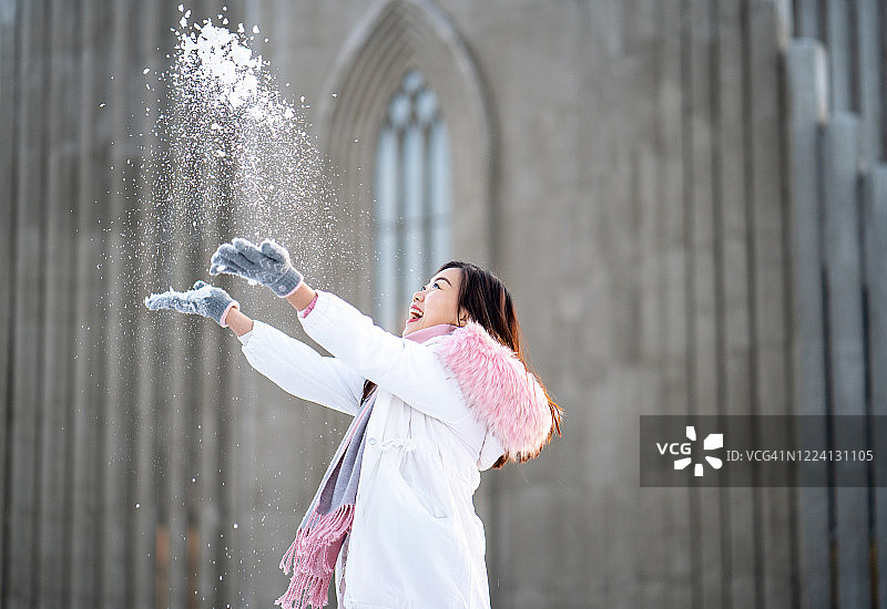 快乐的年轻亚裔女性在玩雪图片素材