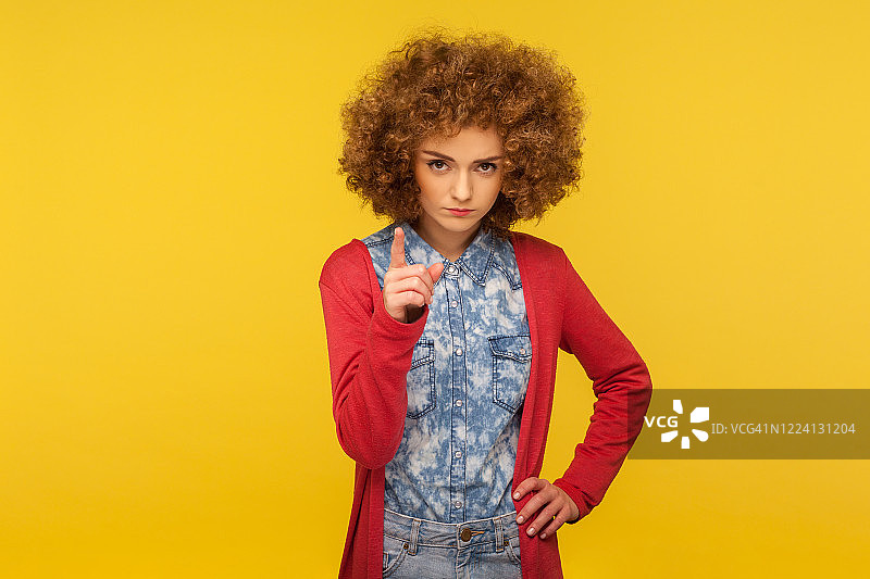 小心！表情严肃的卷发女子给出建议图片素材