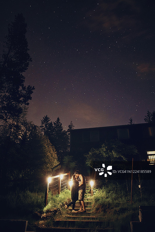 夜晚，夫妻在室外楼梯上拥抱图片素材