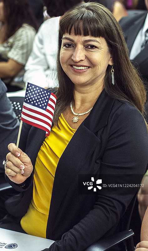 挥舞旗帜的西班牙裔移民即将成为美国公民图片素材