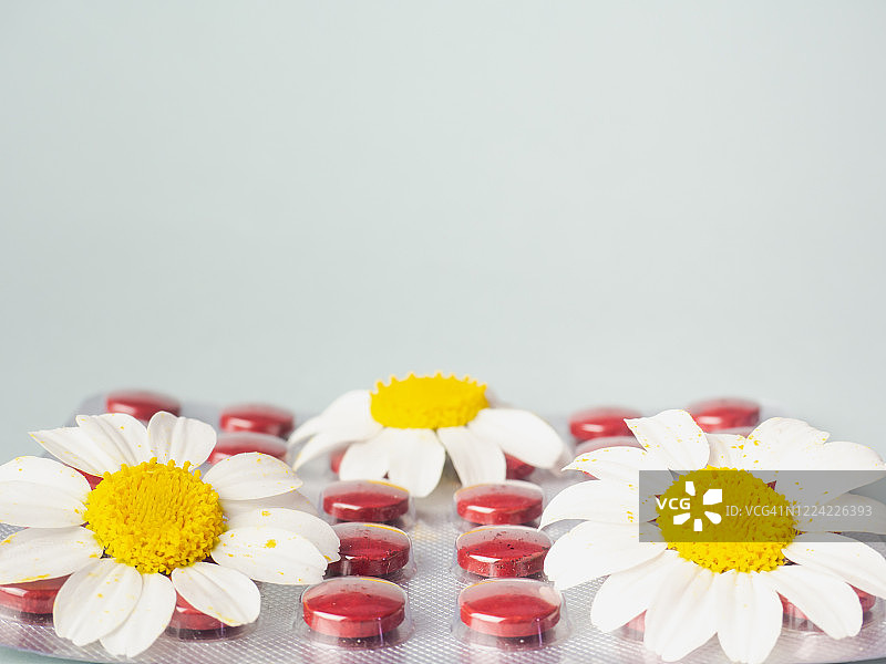 药片和平板电脑与鲜花：顺势疗法和自然医学概念图片素材