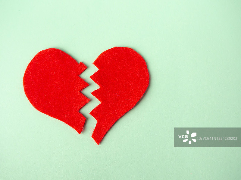 绿色背景下的破碎的心，心碎的概念图片素材