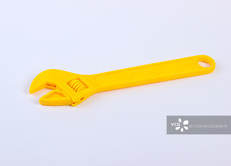 白色背景上的黄色玩具塑料扳手特写图片素材