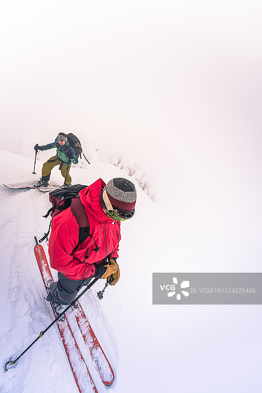 雾中滑雪到达山顶的两个人图片素材