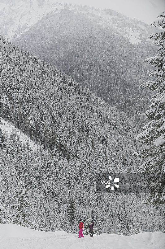 两位年轻女性在冬季的曼宁公园向远处镜头挥手图片素材