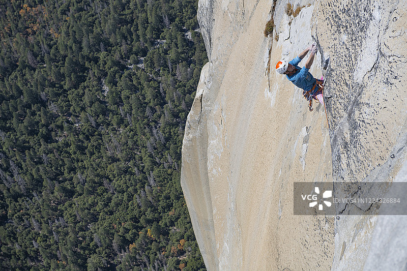 攀岩者在酋长岩顶部的屋檐上攀爬图片素材