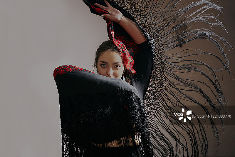 年轻女人在黑色背景上跳弗拉明戈舞图片素材