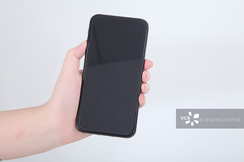手持空白智能手机，白色背景图片素材