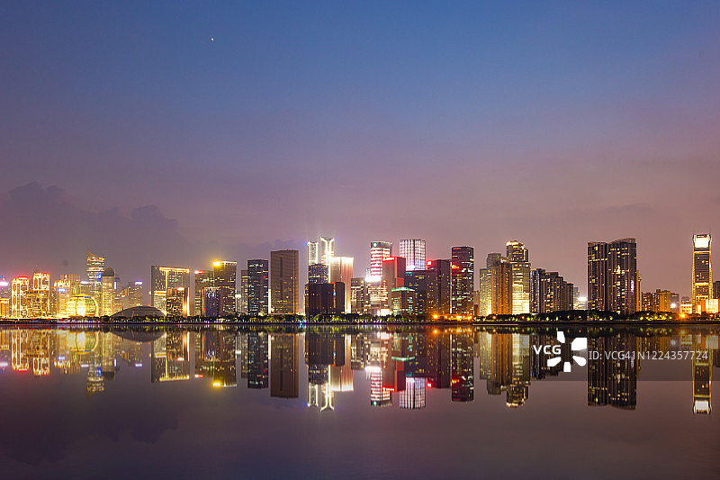 现代城市黎明时分的河边城市景观图片素材