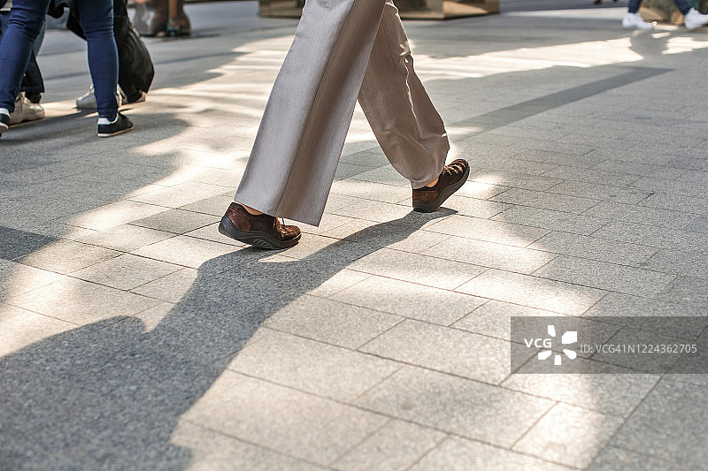 人腿和不同的鞋子走在人行道上图片素材