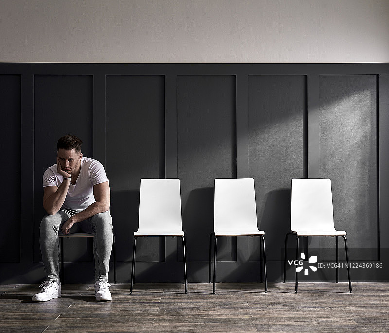 在候诊室等待的年轻男人图片素材