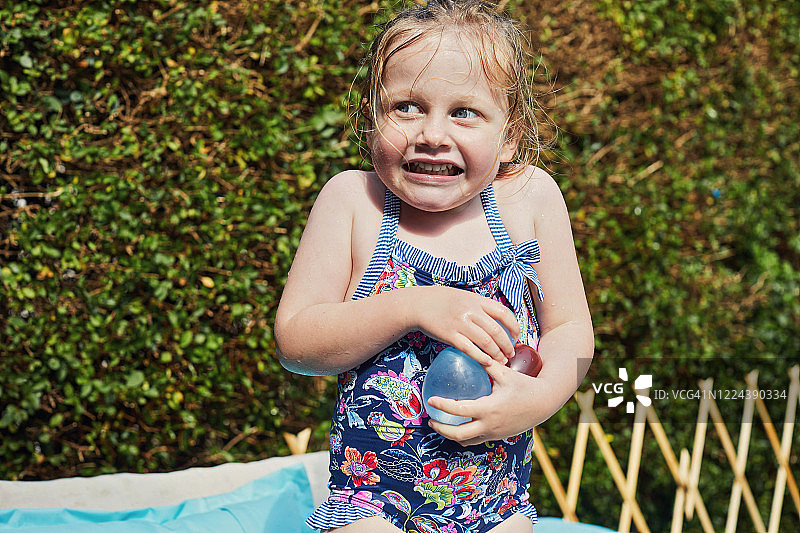 儿童在戏水池里拿着水气球图片素材