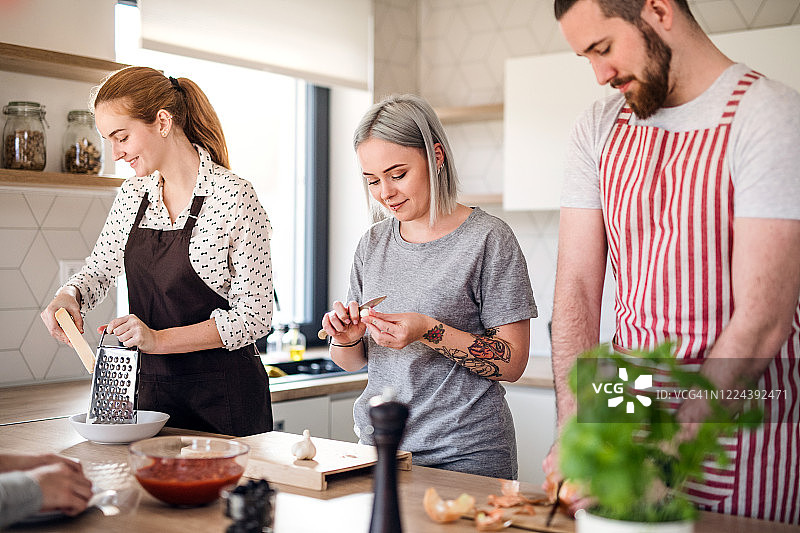 一群年轻人在家里的厨房做饭图片素材