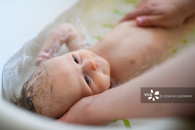 母亲在家中给宝宝洗澡图片素材