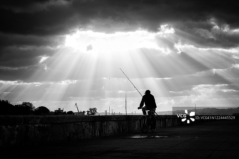 阳光下骑自行车的渔夫图片素材