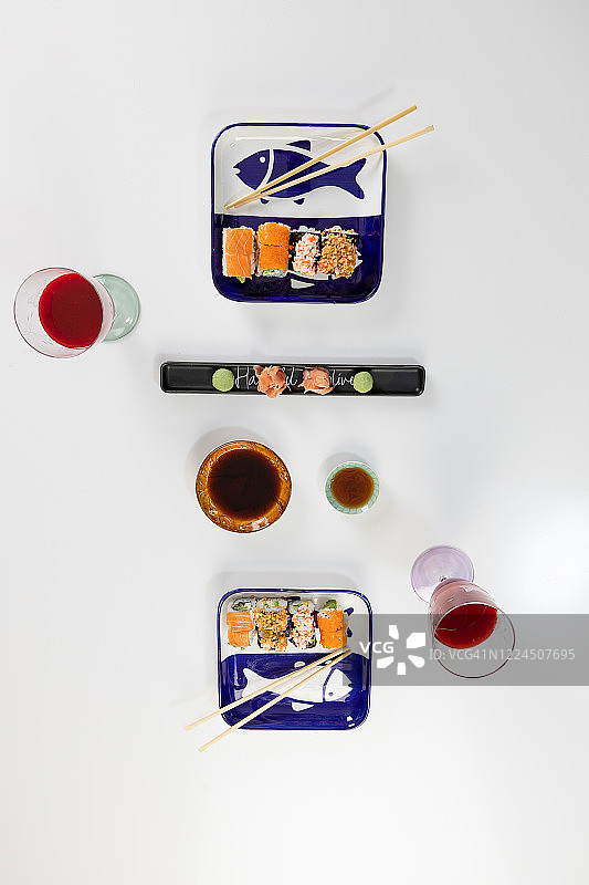 寿司和卷物拼盘，含三文鱼、金枪鱼、牛油果、加州卷、寿司卷、酱油、筷子特写图片素材