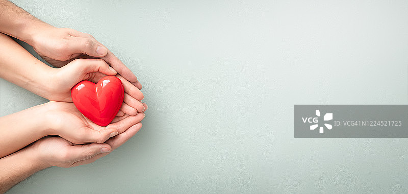 成人和儿童手 holding 红心图片素材