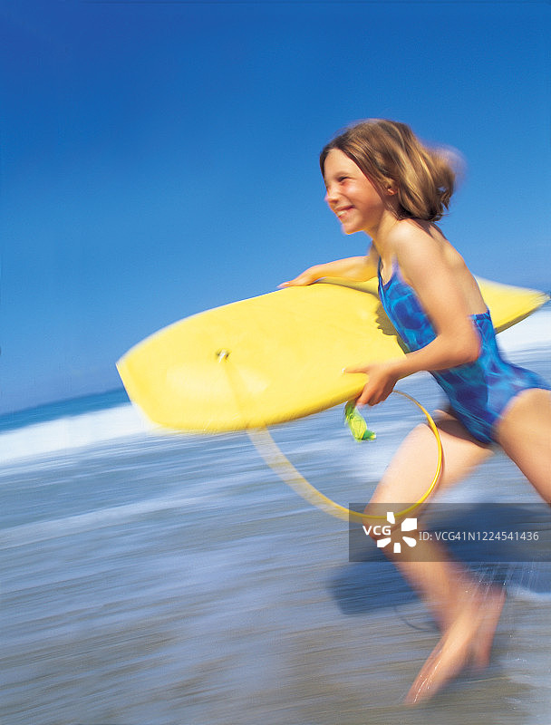 女孩带着趴板冲向大海图片素材