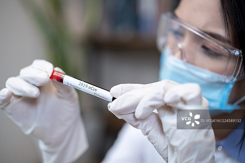 亚洲女医生分析冠状病毒血液样本图片素材