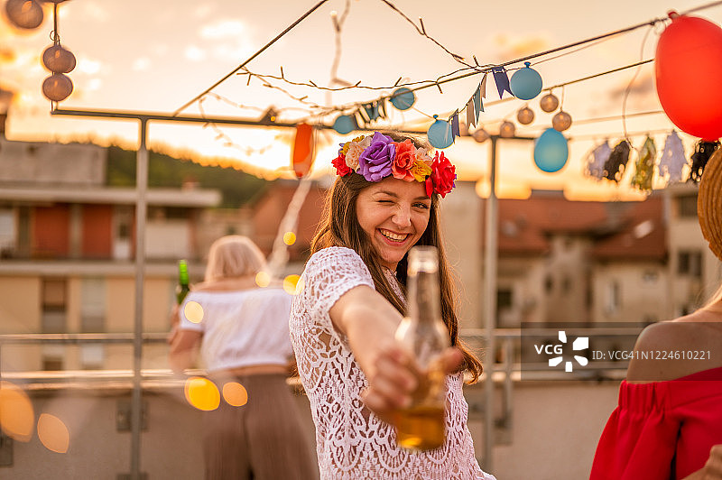 一群年轻人在日落时分的屋顶派对上玩耍图片素材