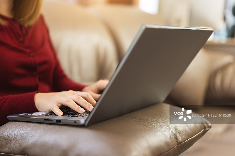 在家中沙发上使用笔记本电脑上网的亚洲女性图片素材