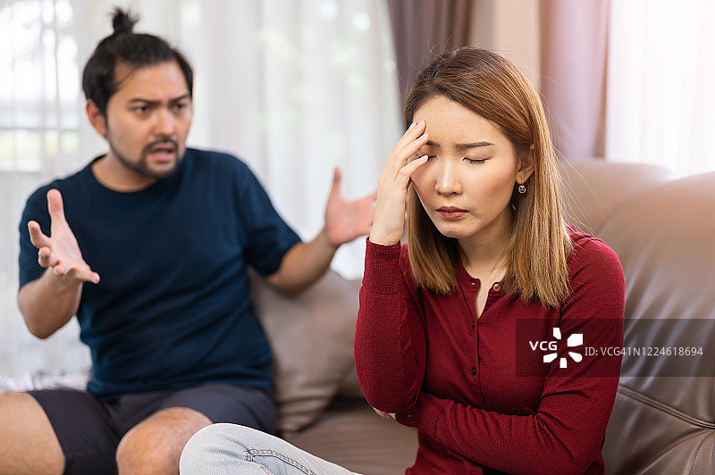 在家中沙发上争吵的年轻亚洲夫妇图片素材