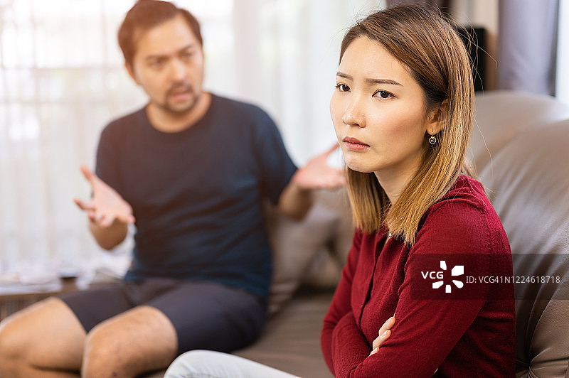 在家中沙发上争吵的年轻亚洲夫妇图片素材