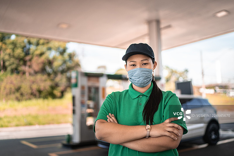 戴口罩工作的女加油站服务员肖像图片素材