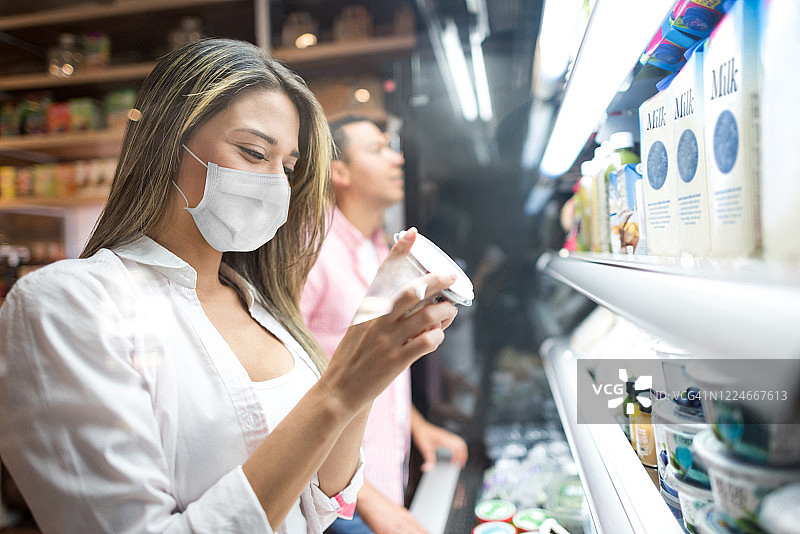 戴着口罩在超市购物的女人图片素材