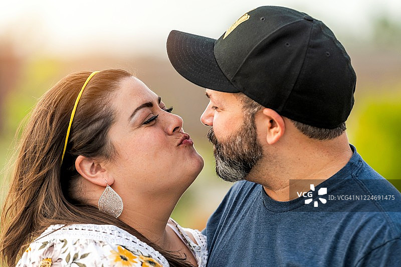 疫情期间，微笑的多种族夫妇在户外亲吻图片素材